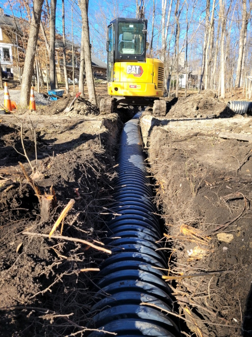 Backfilling the trench to cover the drain tile